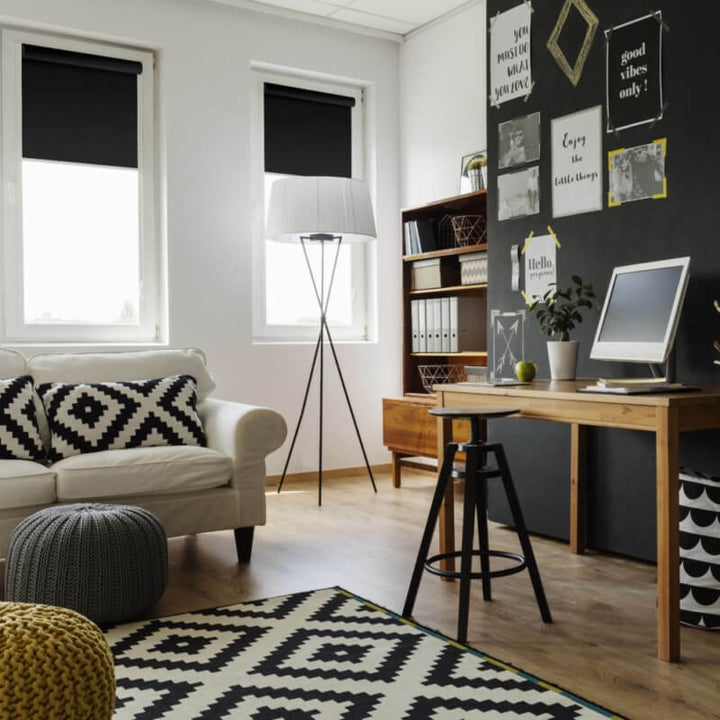 Black roller blinds on white wall in living room