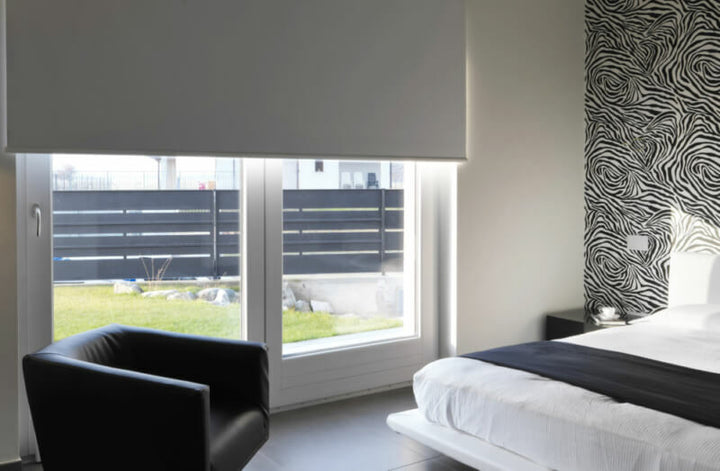 White roller blind in bedroom with white pattern walls