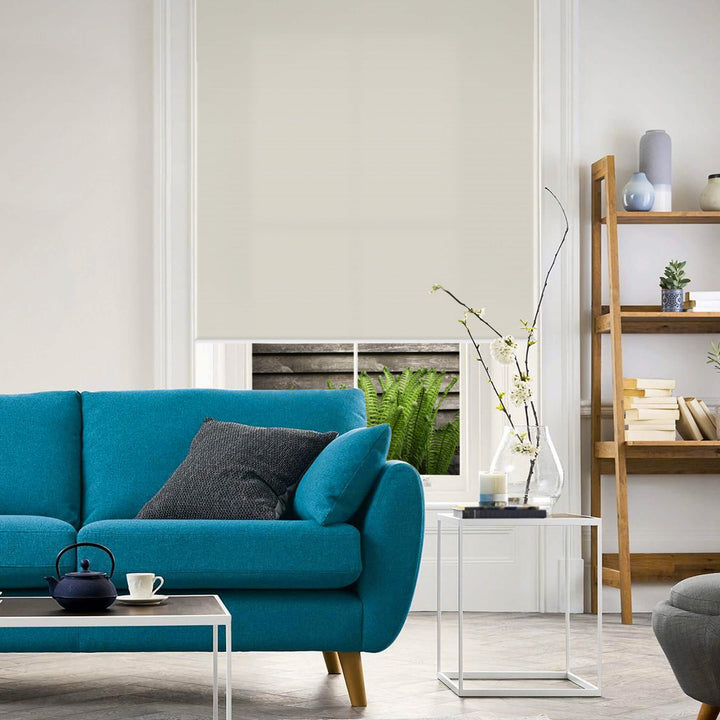 White roller blinds in room with blue couch and decor
