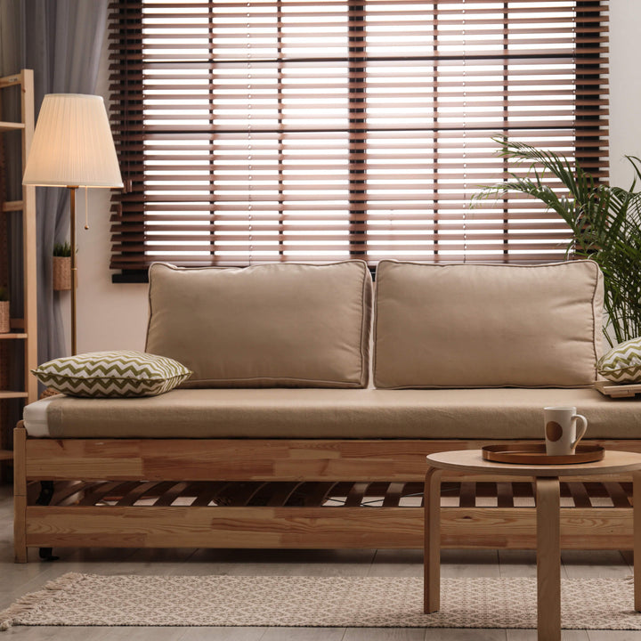 Wooden blinds in living room with beige couch